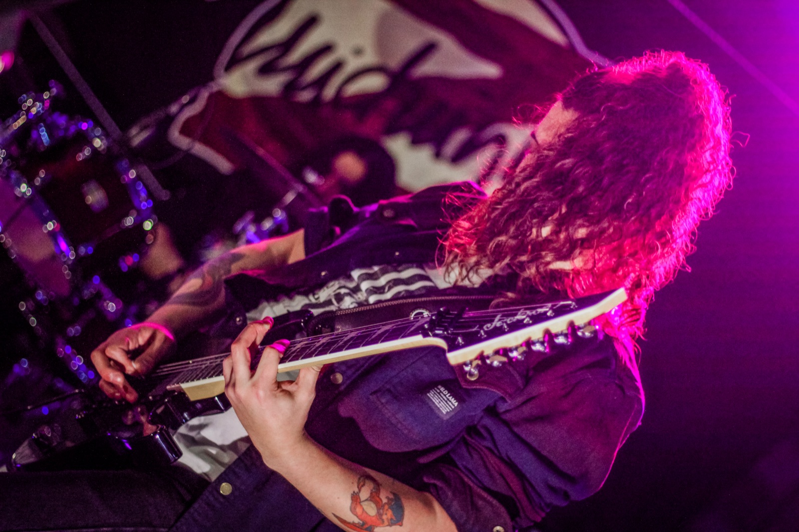 Guitarra en vivo de Midnight-Z con luces magenta en una convención
